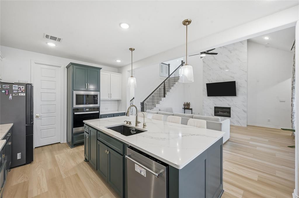 2188 Cloverfern Way Haslet, TX 76052 - Photo 7 of 30 a kitchen with stainless steel appliances kitchen island a wooden floor and a view of living room