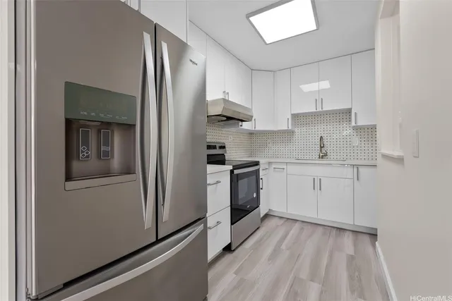 a kitchen with a refrigerator sink and cabinets