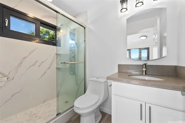 a bathroom with a granite countertop sink toilet and shower