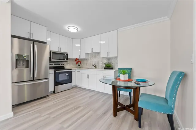 a kitchen with stainless steel appliances a table chairs refrigerator and microwave