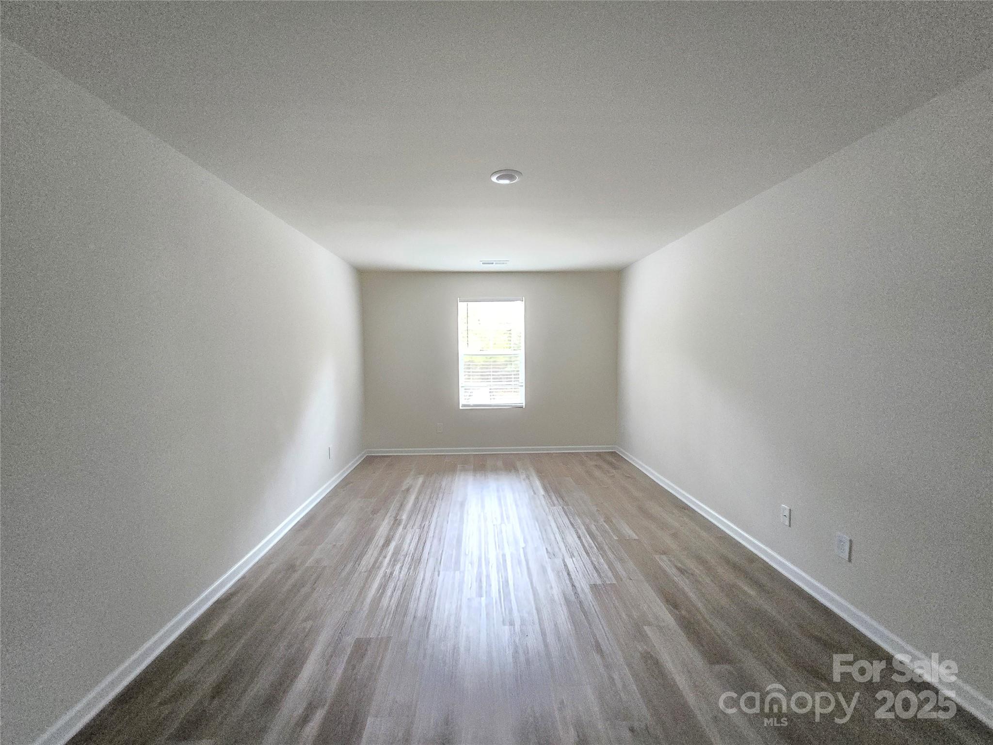 103 Spring Drive Salisbury, NC 28144 - Photo 7 of 21 an empty room with wooden floor and windows