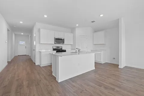a kitchen with white cabinets and stainless steel appliances