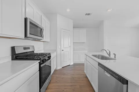 a kitchen with stainless steel appliances granite countertop a sink stove and refrigerator