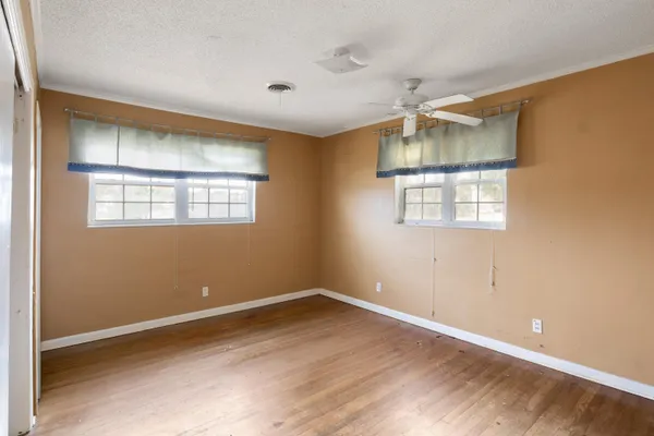 an empty room with a window and wooden floor