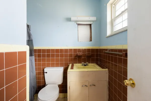 a bathroom with a toilet a sink and a mirror