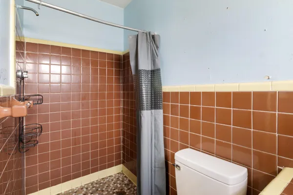 a bathroom with a toilet and a shower