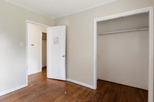 a view of an empty room with wooden floor