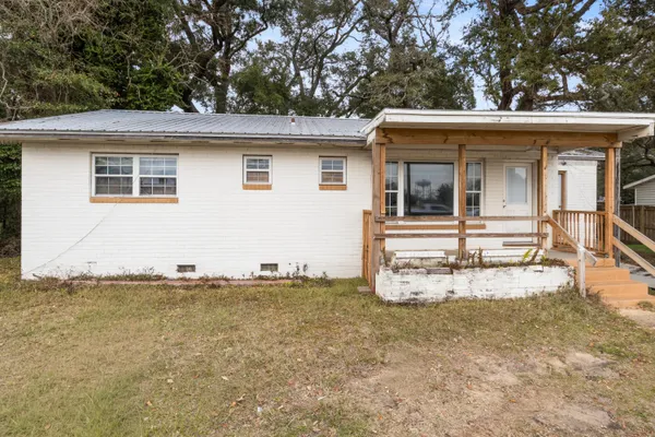 a view of a house with a small yard and wooden fence