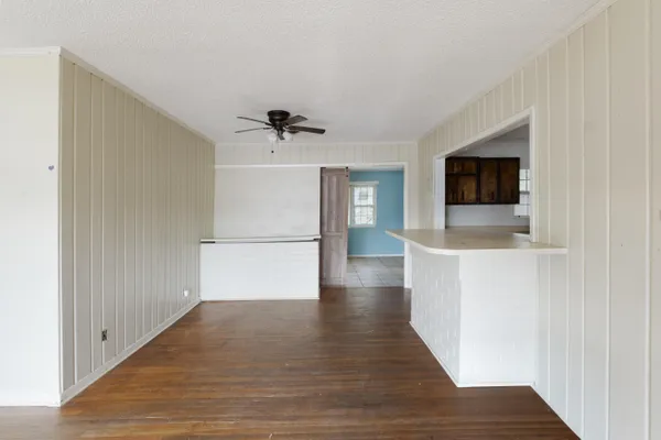 a view of a livingroom with wooden floor and a ceiling fan