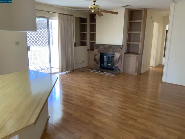 a view of empty room with wooden floor and fireplace