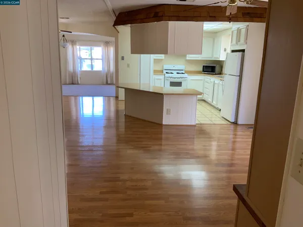 a kitchen with stainless steel appliances a refrigerator and wooden floor