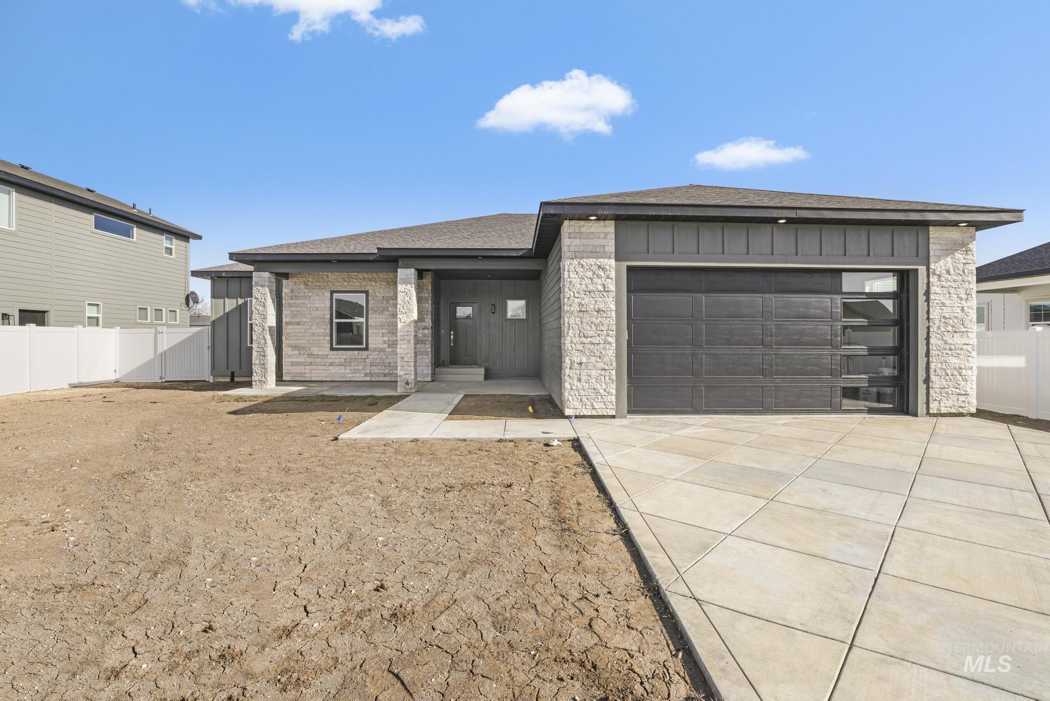 Prairie-style home with driveway, a garage, roof with shingles, and brick siding