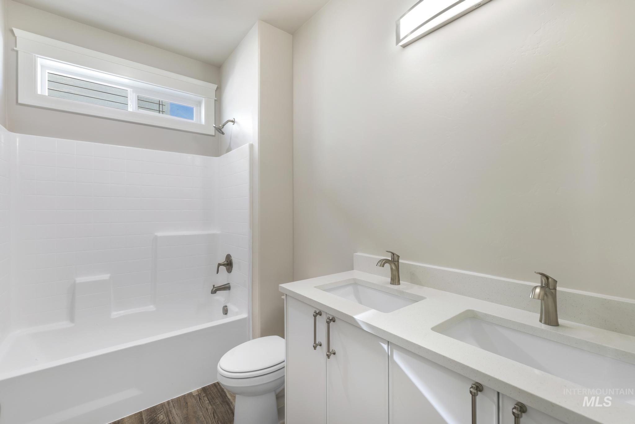 1316 K Street Rupert, ID 83350 - Photo 24 of 44 Full bath with double vanity, shower / bath combination, and dark wood-style flooring