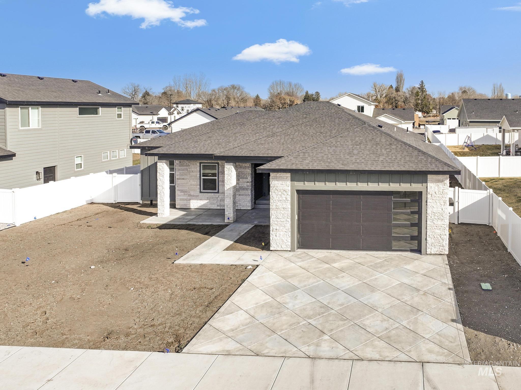 1316 K Street Rupert, ID 83350 - Photo 30 of 44 View of front of house featuring a residential view, roof with shingles, a fenced backyard, and concrete driveway