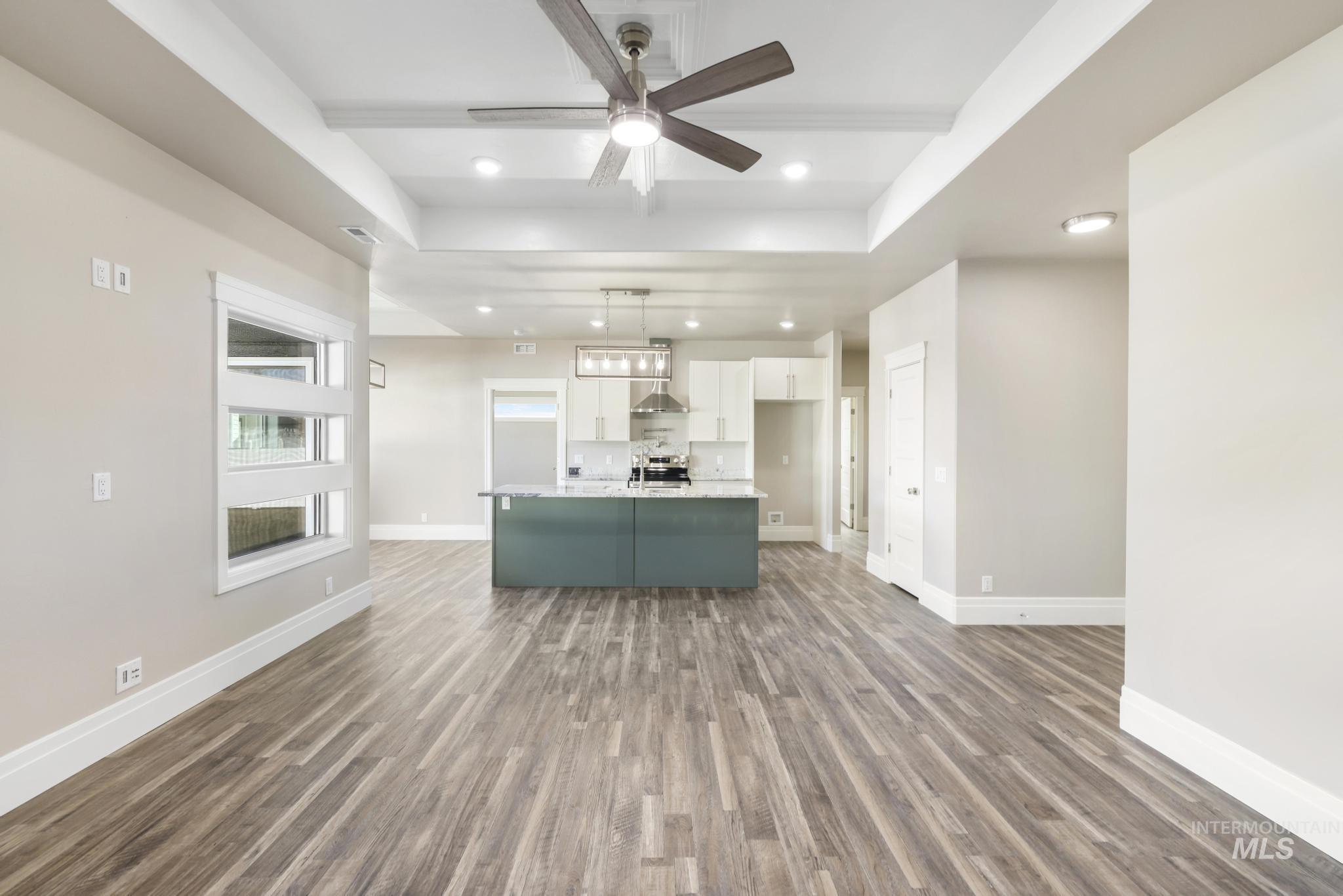 1316 K Street Rupert, ID 83350 - Photo 43 of 44 Kitchen with an island with sink, open floor plan, a ceiling fan, dual tone cabinetry, and dark wood-type flooring