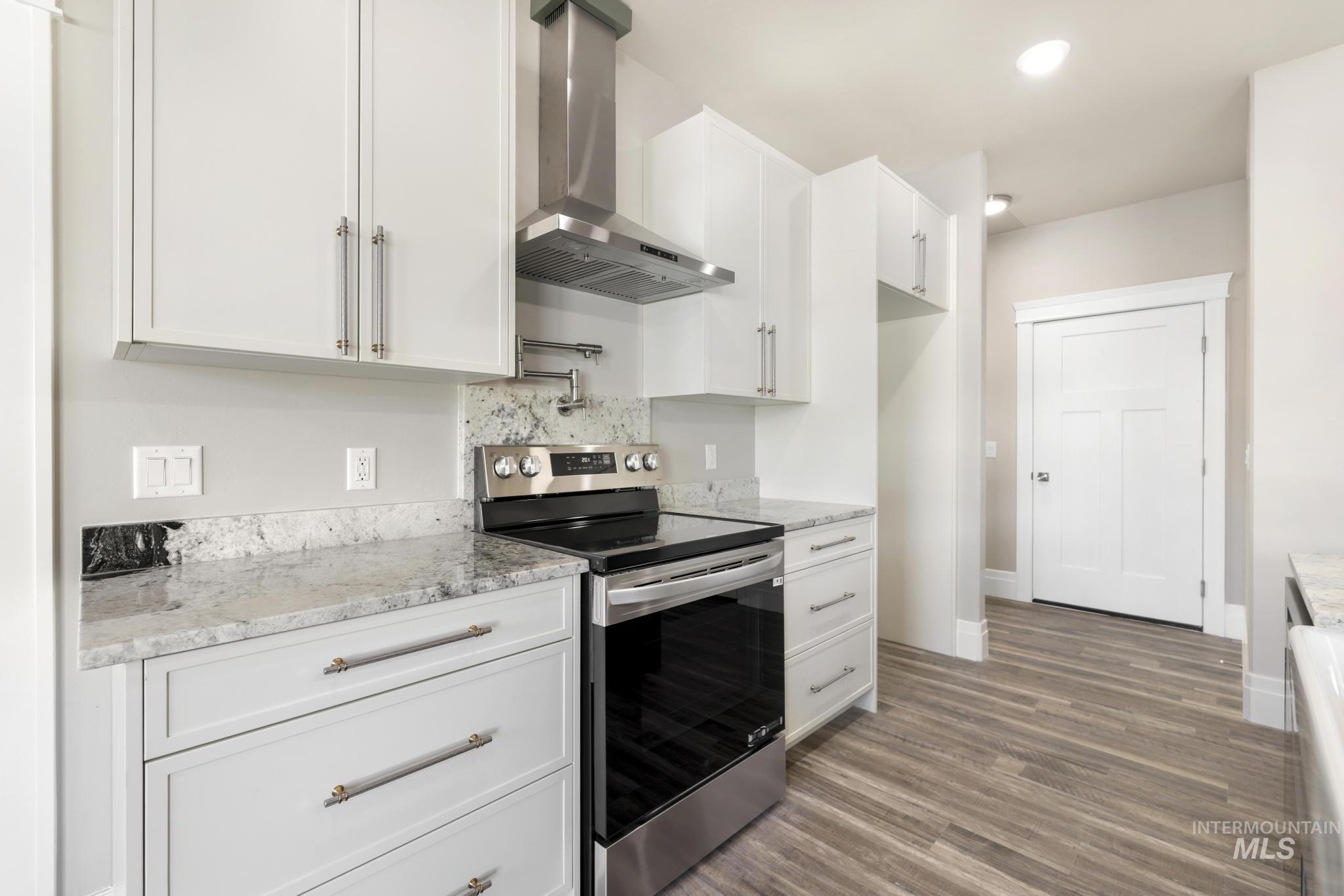 1316 K Street Rupert, ID 83350 - Photo 8 of 44 Kitchen featuring stainless steel range with electric stovetop, white cabinetry, light stone counters, tasteful backsplash, and recessed lighting