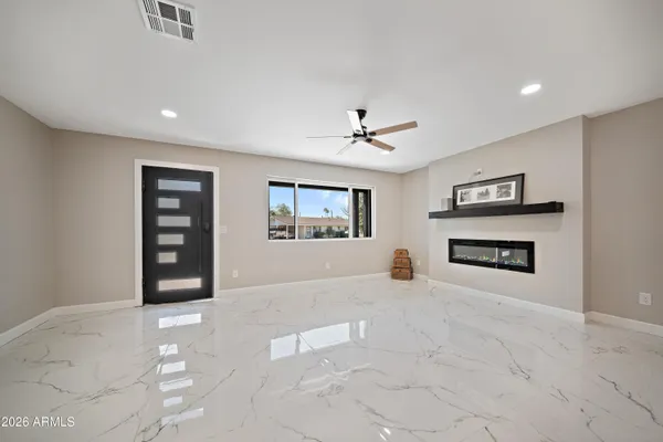 a view of an empty room with a window and a fireplace
