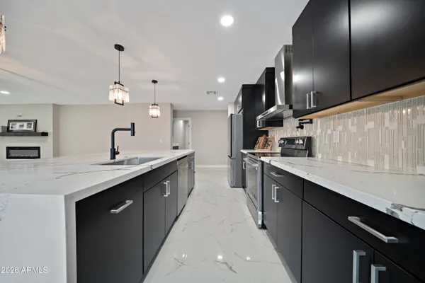 a large kitchen with stainless steel appliances kitchen island a large counter space a sink and cabinets