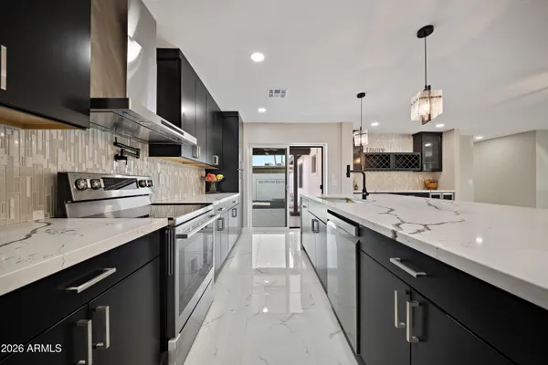 a large kitchen with stainless steel appliances kitchen island granite countertop a sink counter space a stove and cabinets