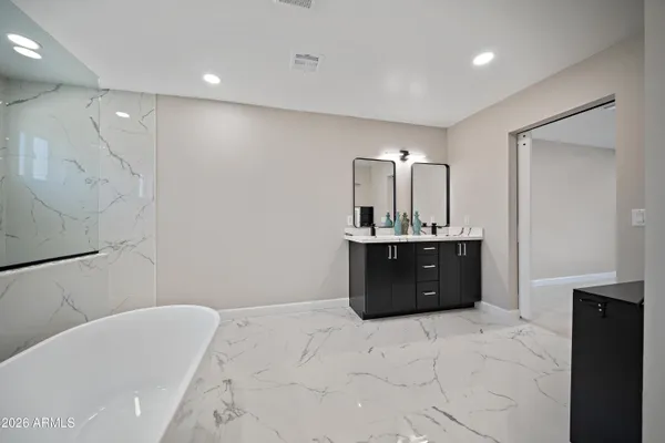 a bathroom with a bathtub sink vanity and mirror