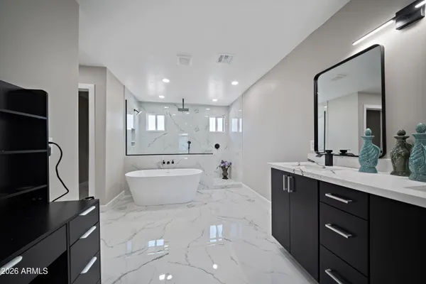 a bathroom with a double vanity sink a mirror and a bathtub