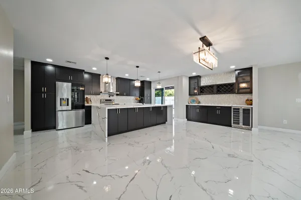 a large kitchen with stainless steel appliances a stove top oven a sink dishwasher and cabinets