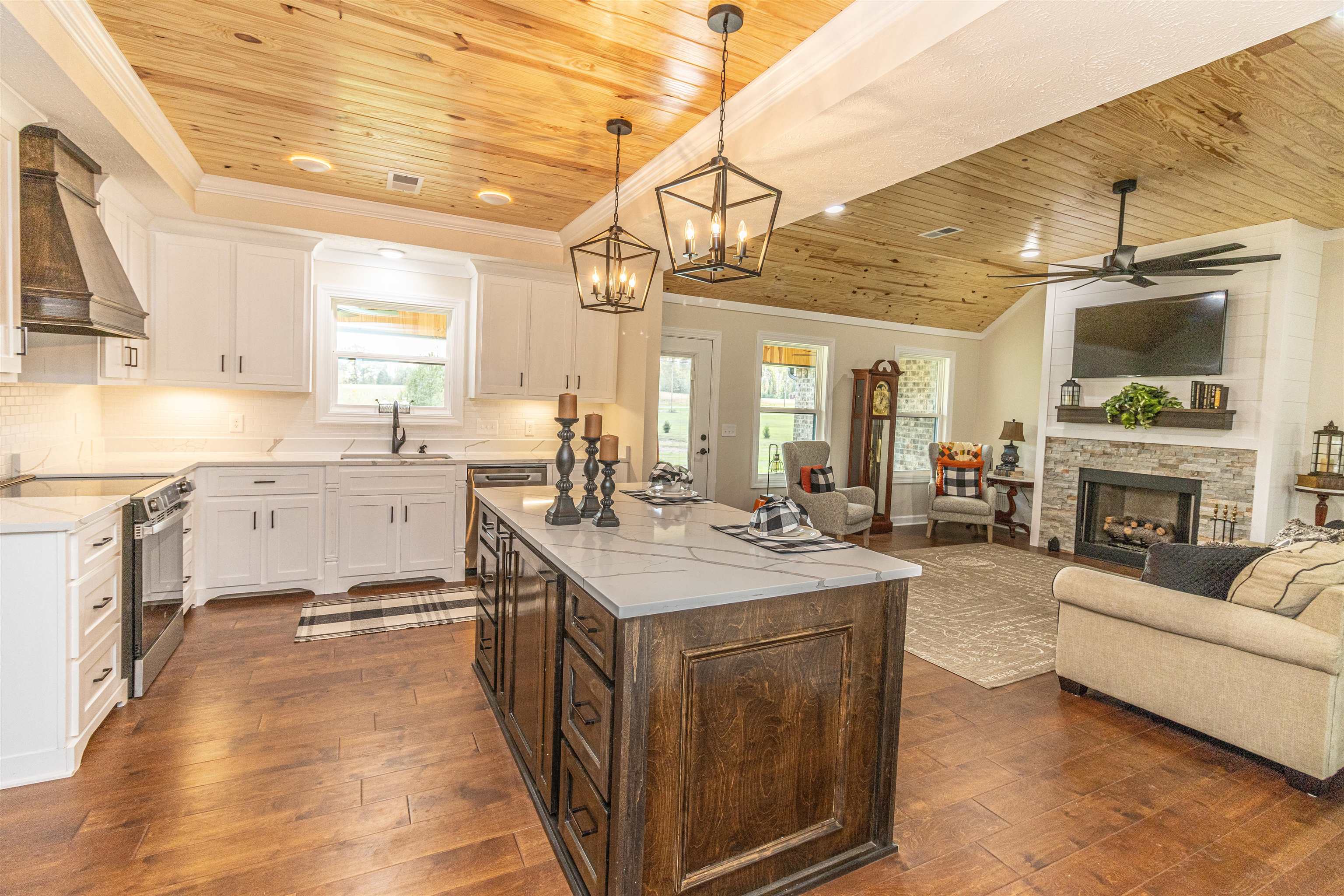 150 Windchase Cove Adamsville, TN 38310 - Photo 13 of 21 Kitchen with dark wood-type flooring, a center island, a healthy amount of sunlight, and appliances with stainless steel finishes