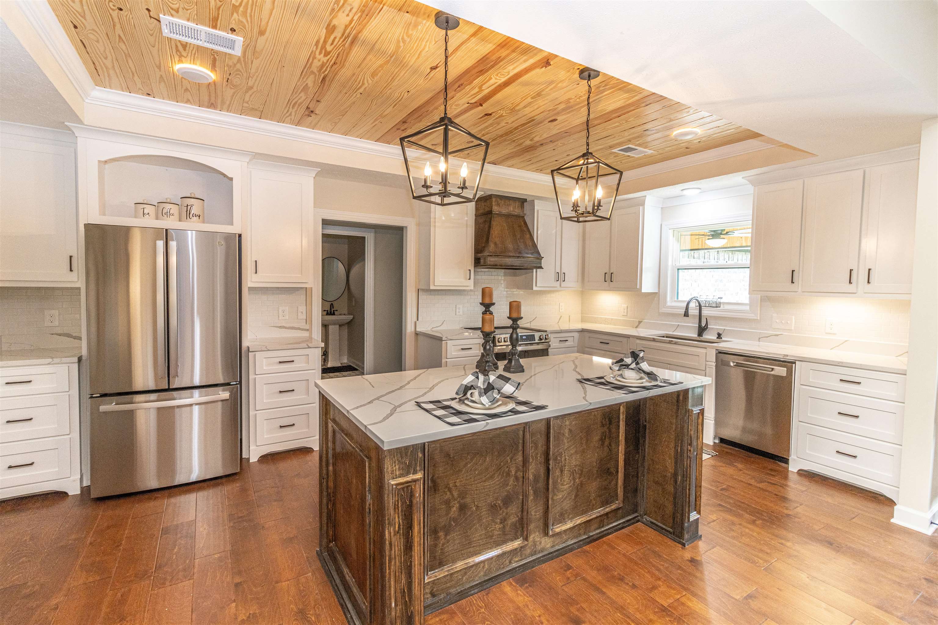 150 Windchase Cove Adamsville, TN 38310 - Photo 9 of 21 Kitchen featuring premium range hood, a center island, appliances with stainless steel finishes, and dark hardwood / wood-style floors