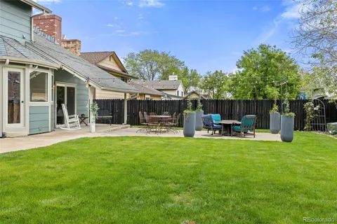 a view of a patio with table and chairs potted plants with large tree