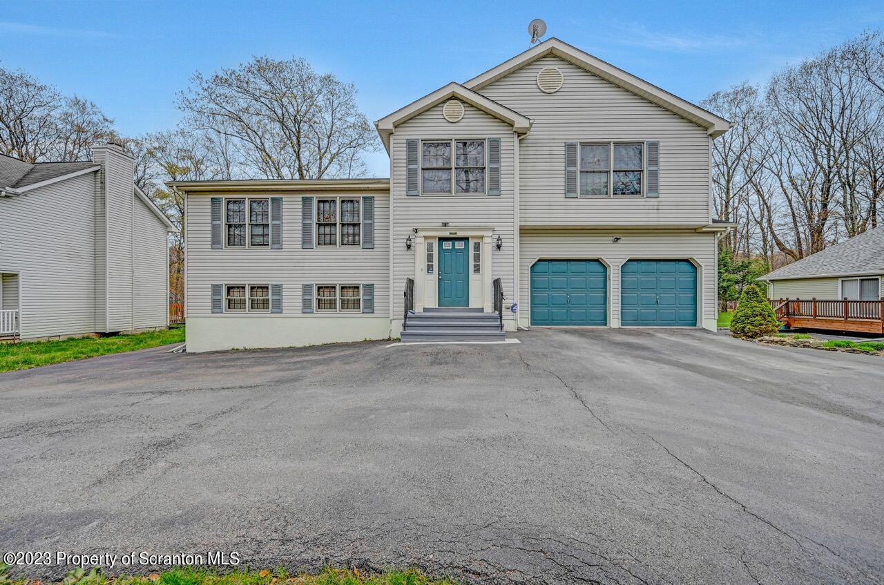 4156 Romeo Road Tobyhanna, PA 18466 - Photo 1 of 46 a front view of a house with a yard and garage