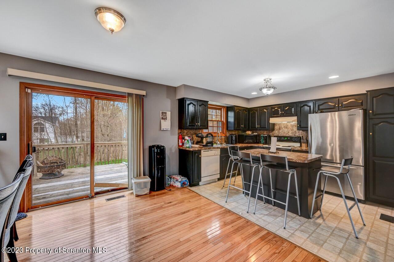 4156 Romeo Road Tobyhanna, PA 18466 - Photo 15 of 46 a kitchen with stainless steel appliances granite countertop a refrigerator oven a sink dishwasher a stove and a dining table with wooden floor