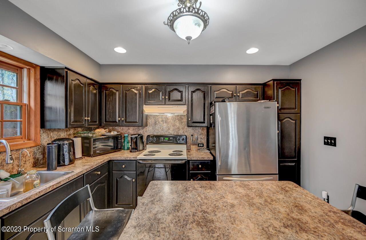 4156 Romeo Road Tobyhanna, PA 18466 - Photo 17 of 46 a kitchen with refrigerator a stove a sink and a cabinets