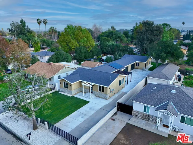 an aerial view of multiple houses with a yard