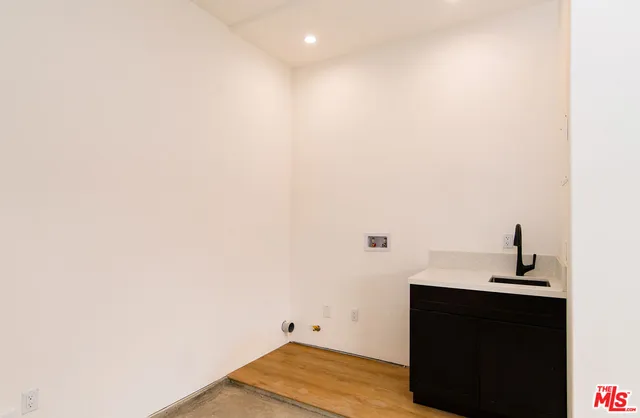 a kitchen with stainless steel appliances granite countertop a sink a stove a refrigerator and a oven with wooden floor