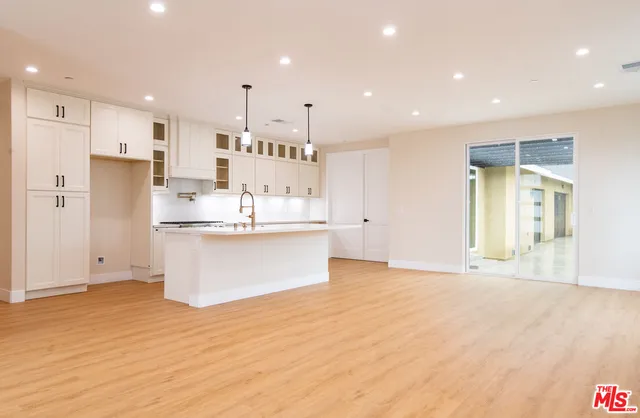 a kitchen with granite countertop a stove and a white cabinets