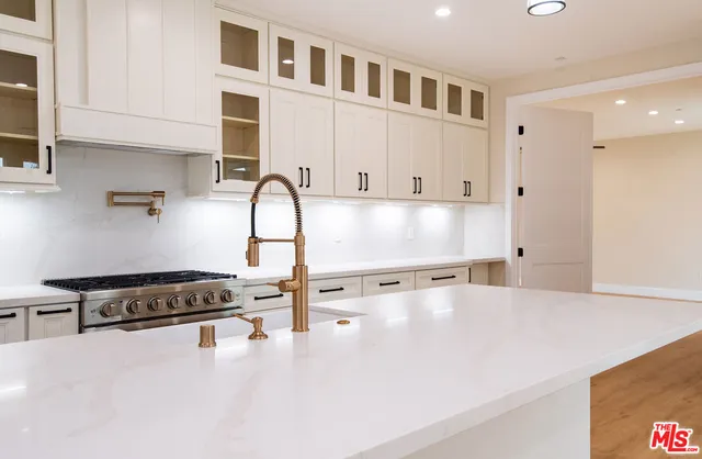 a view of a hallway with wooden floor and a bathroom