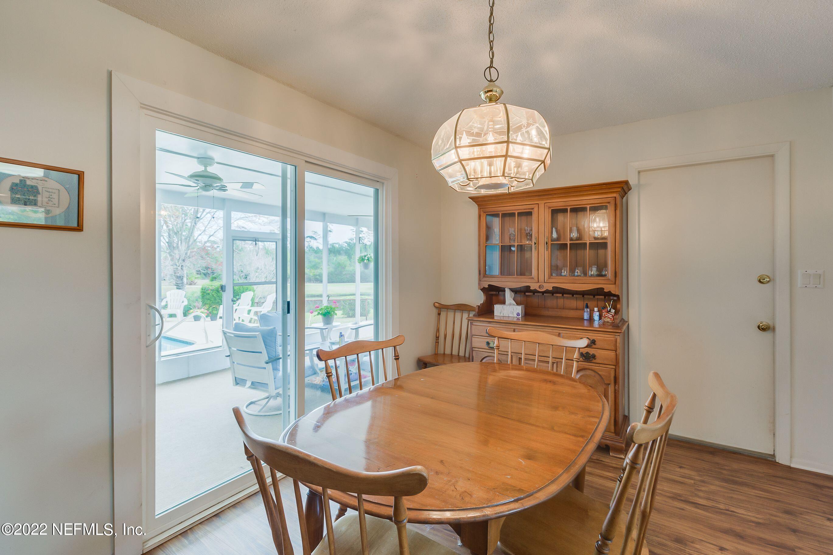 224 Lily Road St. Augustine, FL 32086 - Photo 27 of 52 a dining room with furniture a chandelier and wooden floor