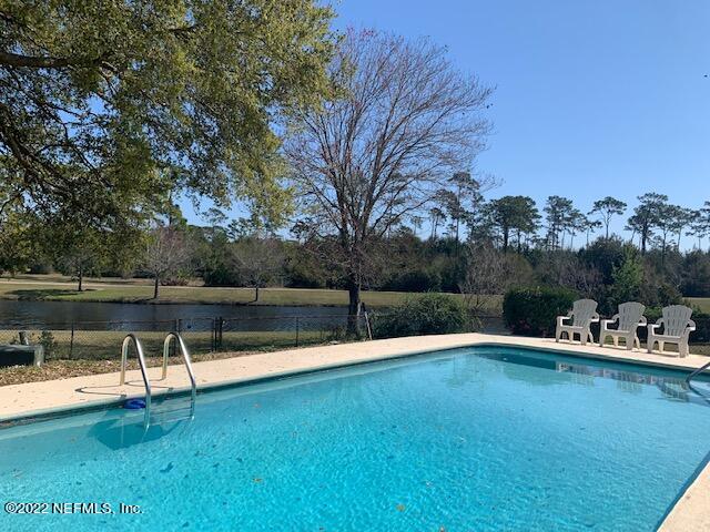 224 Lily Road St. Augustine, FL 32086 - Photo 48 of 52 a view of a lake with a bench and trees around