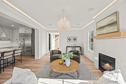 a living room with furniture a fireplace and a chandelier