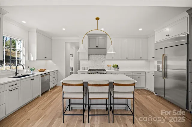 a kitchen with a dining table chairs sink refrigerator and cabinets