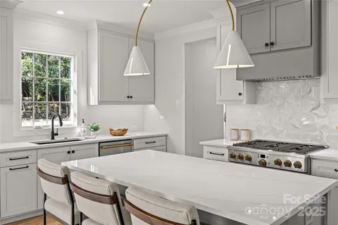 a kitchen with stainless steel appliances a stove a sink and a refrigerator