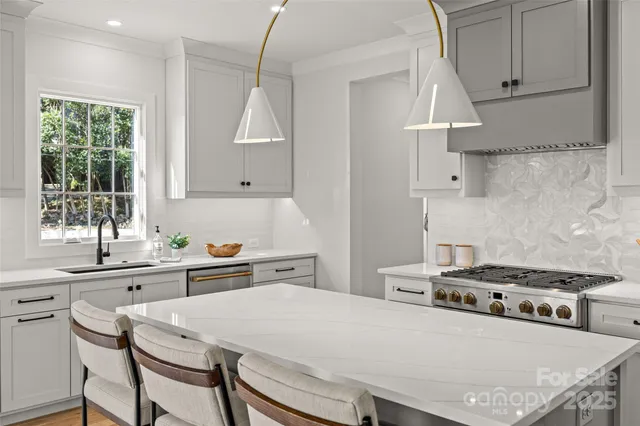 a kitchen with stainless steel appliances a stove a sink and a refrigerator