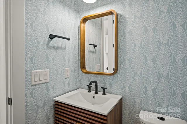 a bathroom with a sink a toilet and mirror