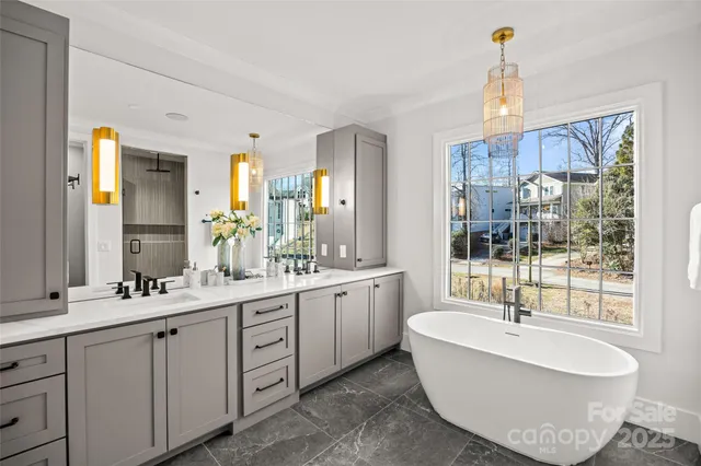 a large spacious bathroom with a double vanity sink a mirror and a bathtub