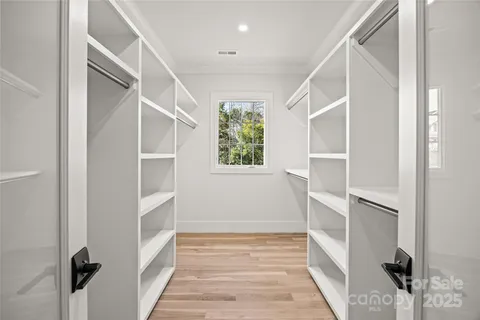 a view of walk in closet with empty racks