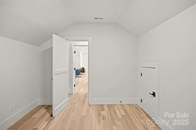 a view of a room with wooden floor and a bathroom