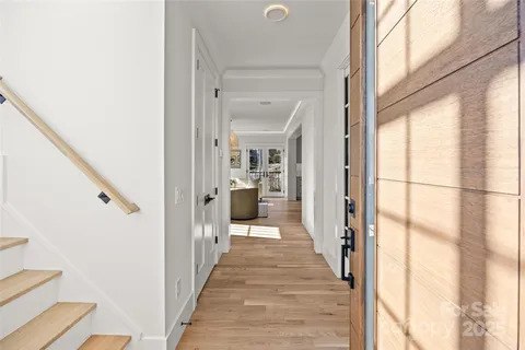 a view of a hallway with wooden floor and staircase