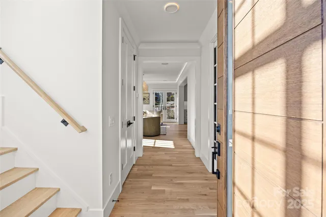 a view of a hallway with wooden floor and staircase