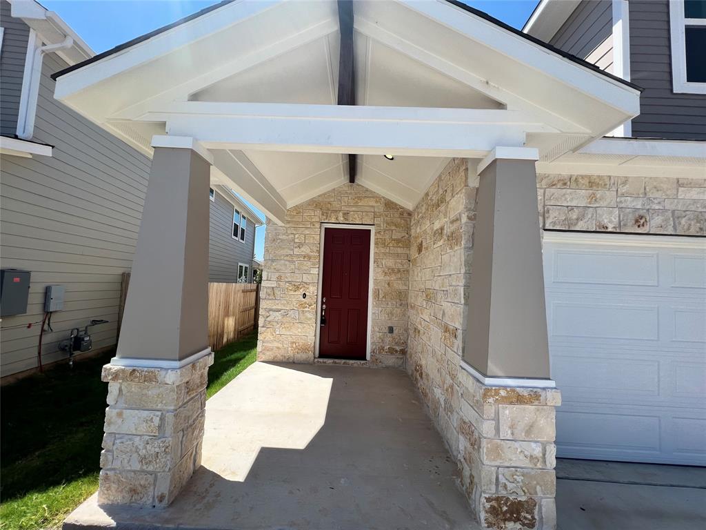 128 Free Stone Drive Georgetown, TX 78628 - Photo 3 of 29 Inviting covered entryway featuring stone veneer accents and a prominent red door