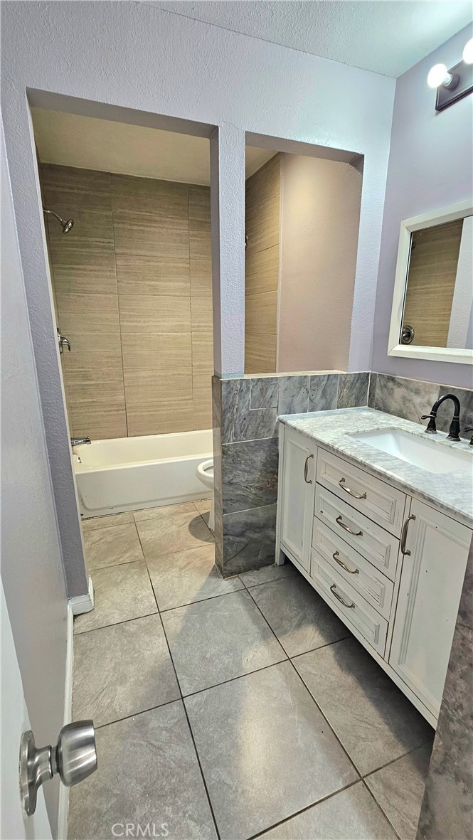 7641 Reseda Boulevard, Unit 87 Reseda, CA 91335 - Photo 18 of 37 a bathroom with a double vanity sink a mirror and a bathtub